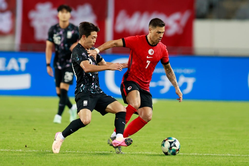 Hong Kong forward Juninho palms off Lee Seung-won during Hong Kong’s 2-0 defeat by South Korea. Photo: Xinhua