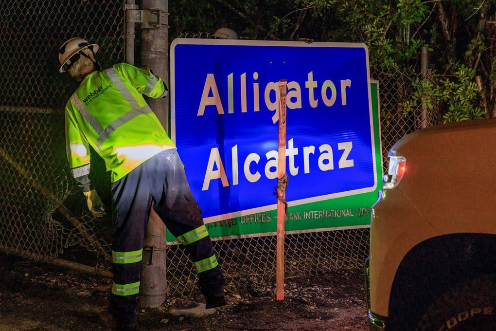 Two workers put up an “Alligator Alcatraz” sign at the entrance of the migrant detention centre in Ochopee, Florida, on July 2. Photo: TNS