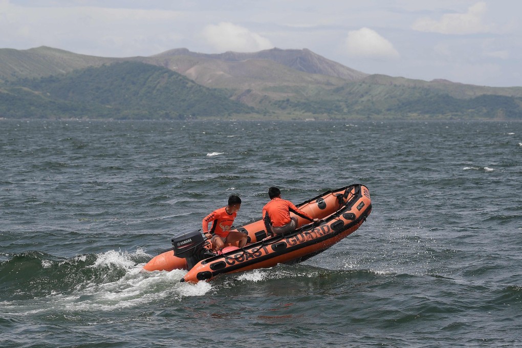 Philippine coastguard personnel aboard an inflatable boat speeds past one of Taal craters on their way to the site where the bodies of cock fighters were allegedly dumped in Taal Lake off Laurel town, Batangas province south of Manila on Thursday. Photo: AFP