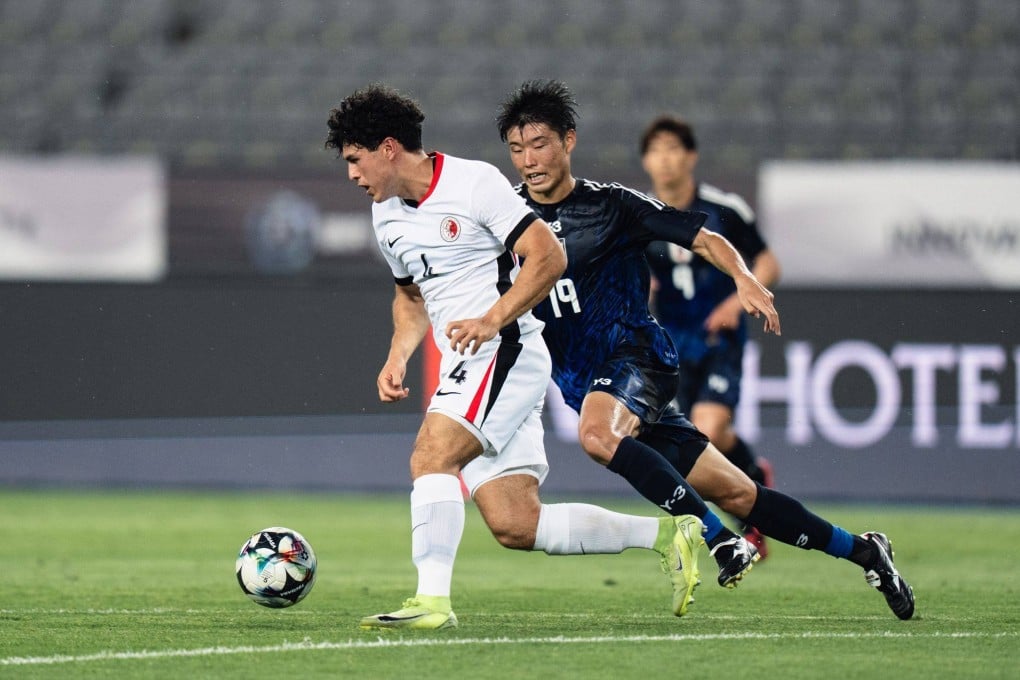 Leon Jones (left) tries to drive clear of Japan forward Yuki Kakita in Hong Kong’s opening East Asian Championship defeat. Photo: HKFA