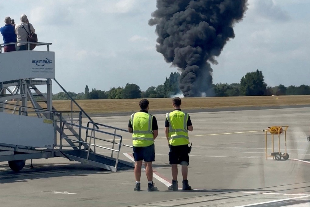 A plume of black smoke rises from an area near the runway after a small plane crash, as seen from inside a building at London Southend Airport, in Southend, Britain on Sunday. Photo: X/ @agussromagnoli/Reuters
