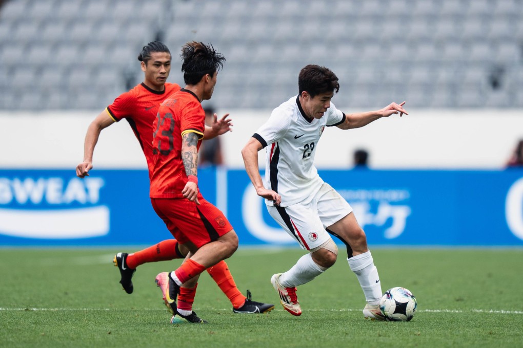 Hong Kong’s Sun Ming-him (right) tries to get clear of China’s Xie Wenneng (left) during the game at Yongin Mireu Stadium. Photo: HKFA