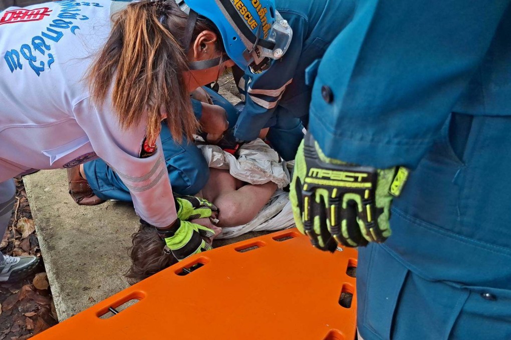 Thai rescuers attending to Jack after he fell through a gap in the concrete slabs covering a drain separating his condo building from a canal in Bangkok. Photo: Poh Teck Tung Foundation