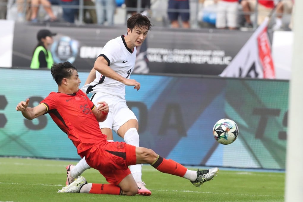 Wumitijiang Yusupu (left) clears the ball away as Matt Orr closes in during Hong Kong’s game against China in the East Asian Football Championship. Photo: Xinhua