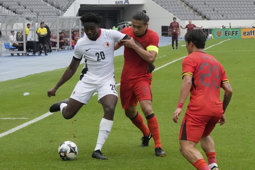 Michael Udebuluzor (left) fights for the ball during Hong Kong’s East Asian Championship clash with China. Photo: AP