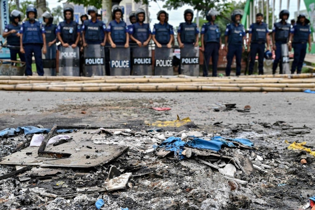 Anti-riot police personnel stand guard near the burnt debris along a street in Gopalganj on Thursday after the clashes during a National Citizens Party rally. Photo: AFP