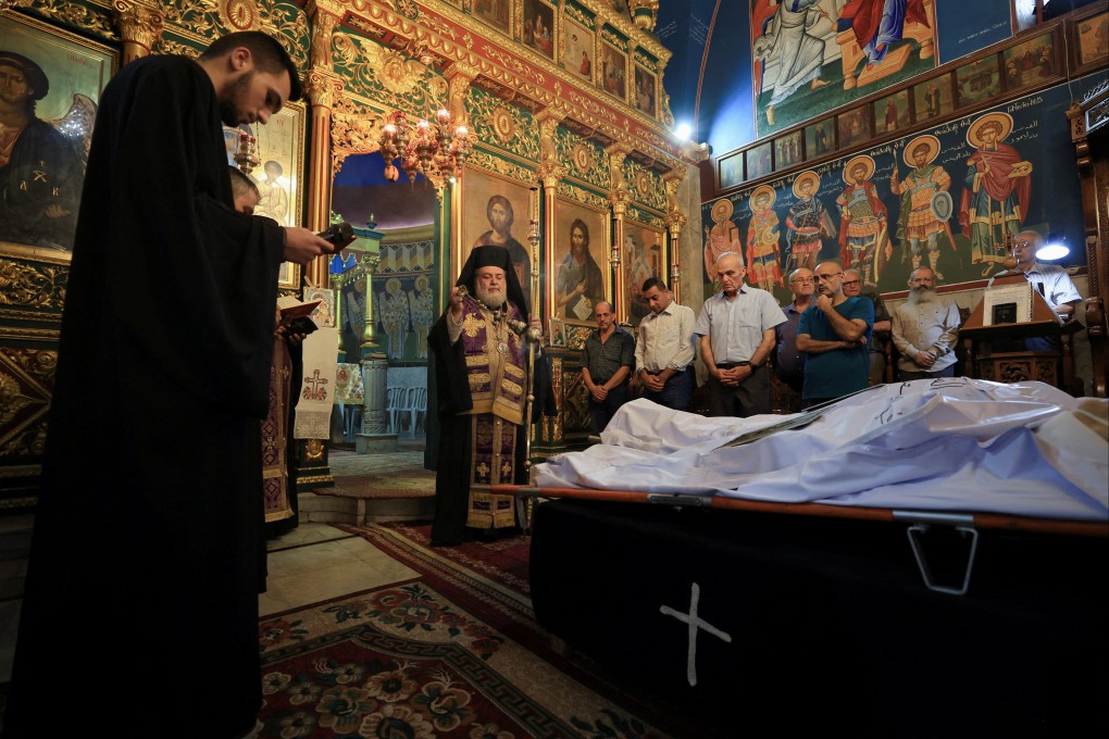 Archbishop Alexios stands in front of the bodies of Palestinian Christians Saad Salama and Foumia Ayyad, who were killed in an Israeli strike on the Holy Family Church. Photo: Reauters