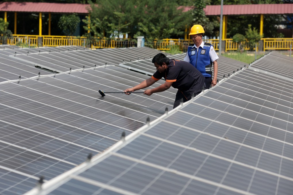 Workers clean solar panels at Jatijajar bus station in Depok, Indonesia on April 16. Photo: EPA-EFE