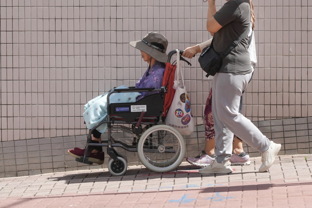 An elderly woman is assisted in To Kwa Wan. The 24-hour ‘182183’ hotline provides emotional support to carers, as well as referrals to welfare services. Photo: Sam Tsang
