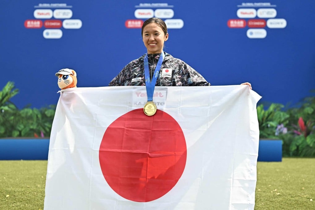 Ichika Kajimoto poses with the Japanese flag after winning the women’s 3km knockout sprint. Photo: AFP