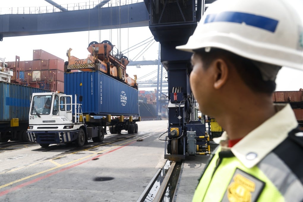 An Indonesian security employee looks at containers being loaded onto transport trucks at the Jakarta International Container Terminal at Tanjung Priok Port in Jakarta, Indonesia, on July 9. Photo: EPA / Bagus Indahono
