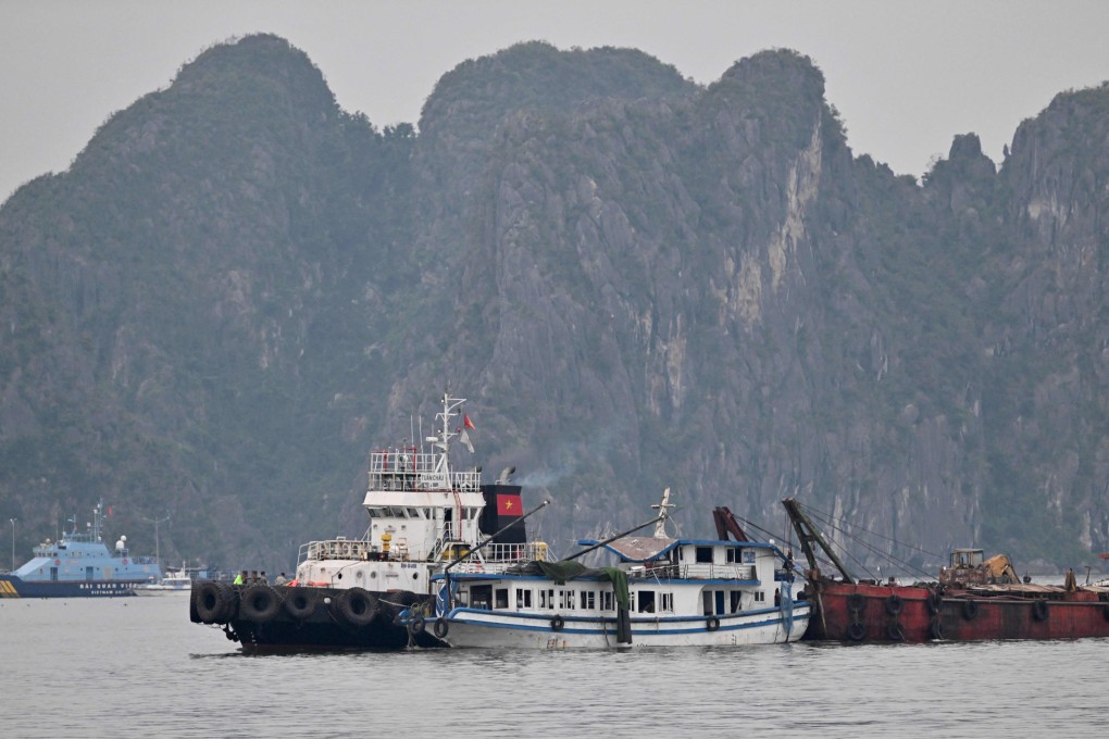 The tourist boat (centre) that capsized is towed back to the port in Ha Long Bay, Vietnam, on Sunday. Photo: AFP