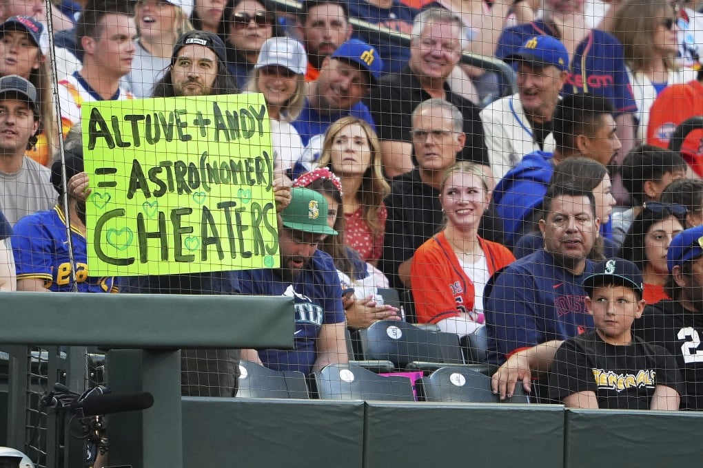 A fan holds up a sign as referencing Houston Astros’ Jose Altuve and Astronomer CEO Andy Byron as Altuve comes up to bat against the Seattle Mariners during the third inning of a baseball game in Seattle on Friday. Photo: AP