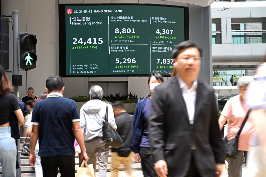 Pedestrians walk in front of an electronic sign showing the Hang Seng Index in Hong Kong on July 11, 2025. Photo: AFP