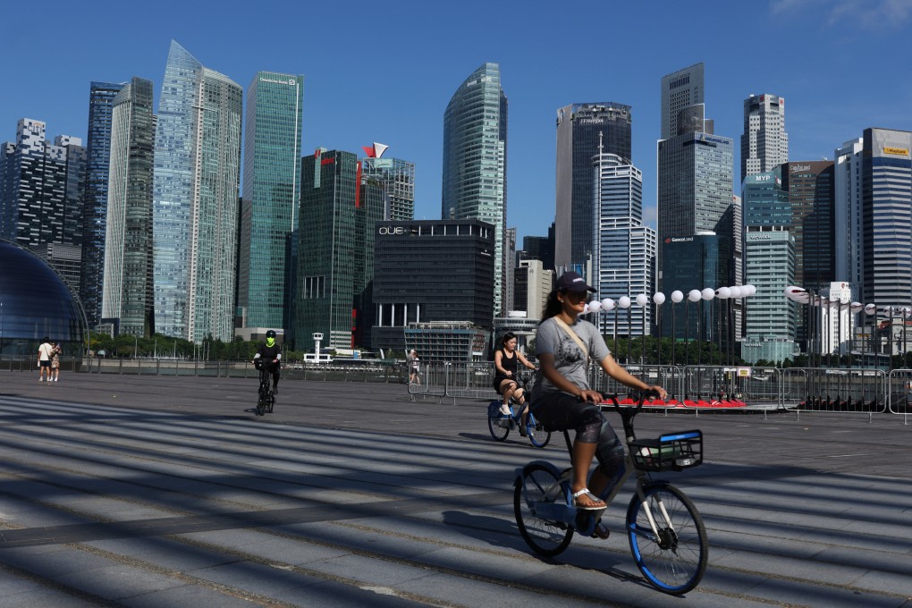 People ride bikes past the skyline of the central business district in Singapore on June 13, 2025. Photo: Reuters