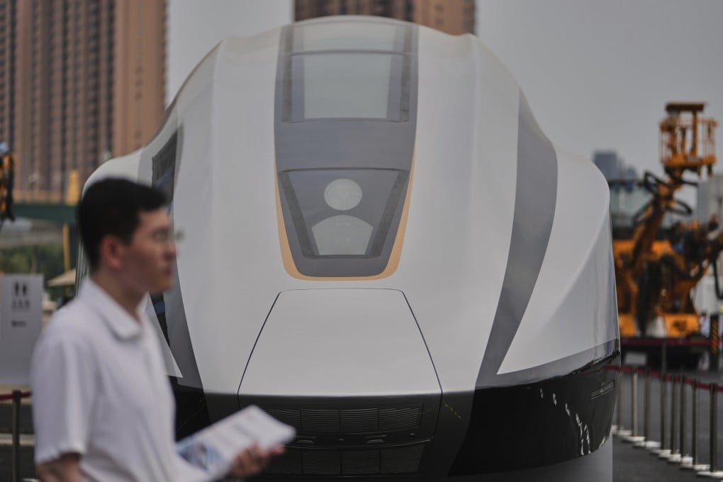 A volunteer holds leaflets as he stands near a 600km High Speed Maglev model showcasing at the National Railway Test Center during a tour by delegates to the World Congress on High-Speed Rail held in Beijing, Wednesday, July 9, 2025. Photo: AP