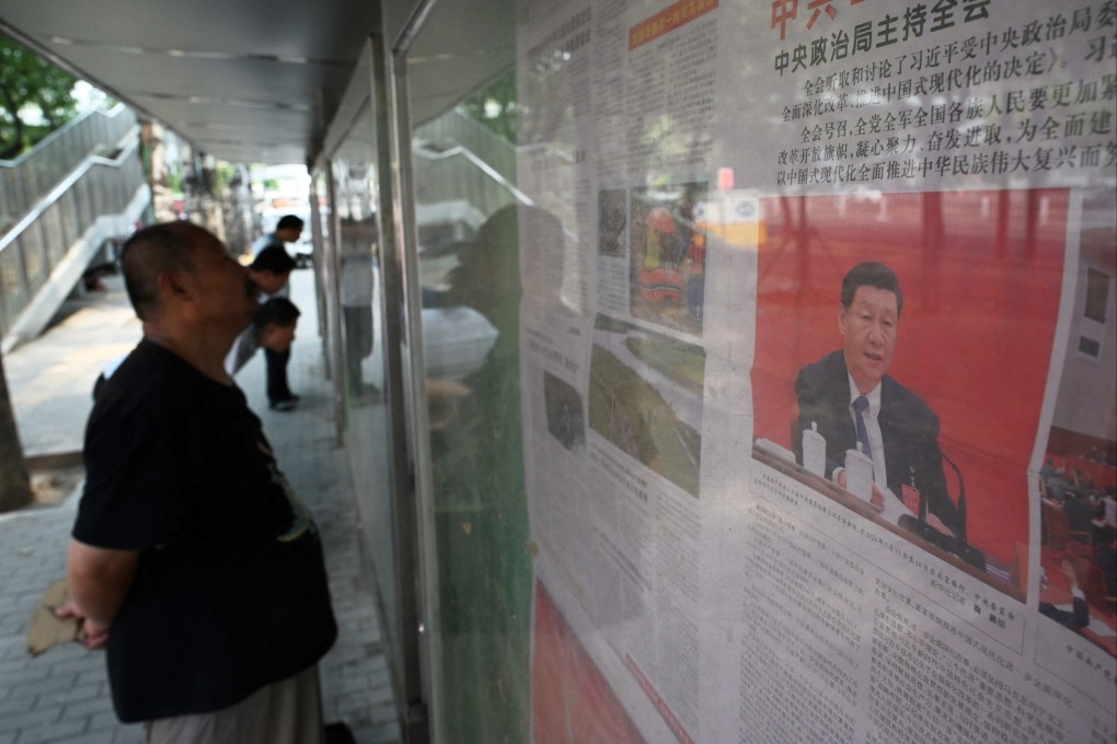 A man reads a state media report about the conclusion of the Third Plenum, on a sidewalk in Beijing on July 19, 2024. Photo: AFP