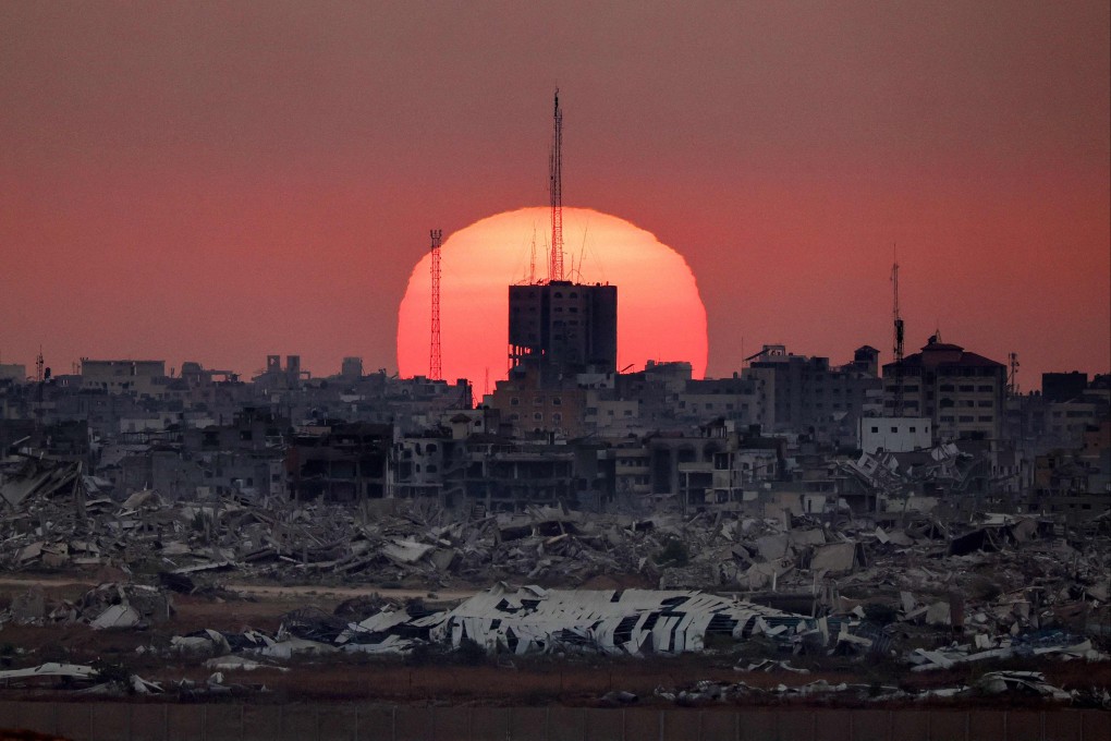 The sun sets behind destroyed buildings in Gaza on July 1. Photo: AFP