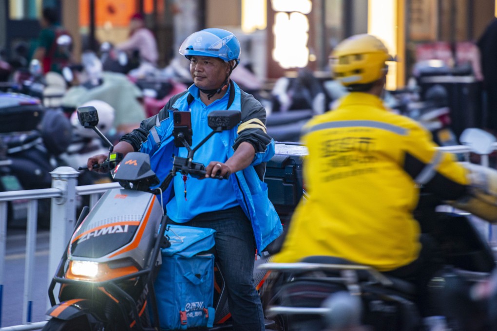Ele.me and Meituan food delivery drivers pass each other on the street in Yancheng, Jiangsu province, on May 14. Photo: Getty Images