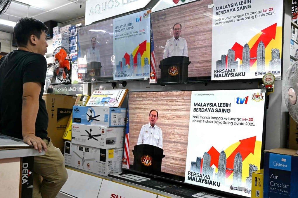 A man watches televisions at a shop in in Bentong, Pahang state, as Malaysian Prime Minister Anwar Ibrahim announces the cash handout during a live telecast on Wednesday. Photo: AFP