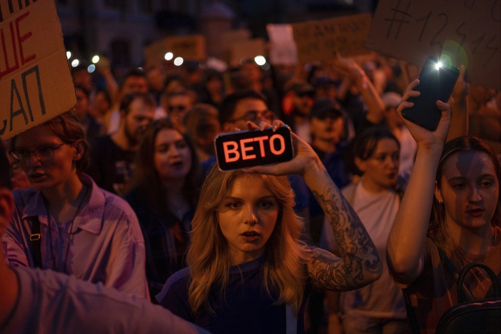 A woman holds a phone with a message that reads ‘Veto’, during a protest in central Kyiv, Ukraine on Tuesday. Photo: AP