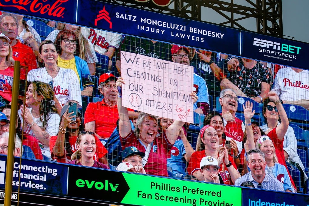 A fan holds up a sign reading “We’re not here cheating on our significant others” during a kiss cam segment of the baseball game between the Philadelphia Phillies and the Los Angeles Angels in Philadelphia, Pennsylvania. Photo: Getty Images