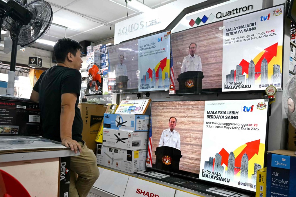 A man watches televisions on display at a shop as Malaysian Prime Minister Anwar Ibrahim addresses the nation during a live telecast on Wednesday. Photo: AFP