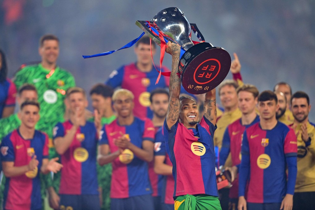 Barcelona’s Brazilian forward Raphinha raises the La Liga trophy as he celebrates with teammates after the match against Villarreal in May. Photo: AFP