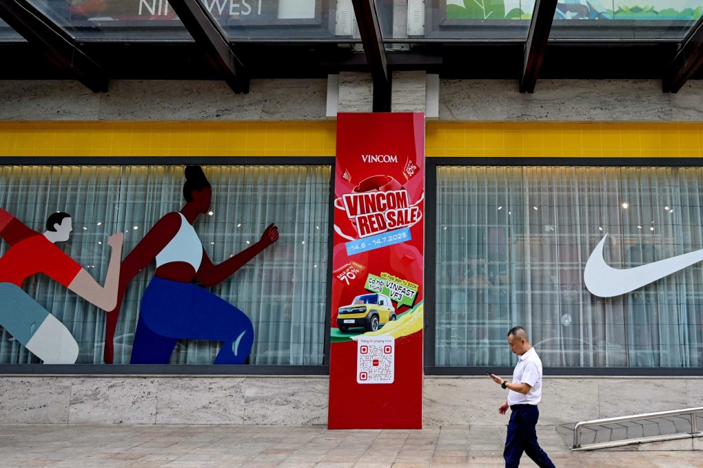 A man walks past a Nike advert outside a shopping centre in Hanoi on July 8. Vietnam has apparently managed to get its initial tariff rate more than halved. Photo: AFP