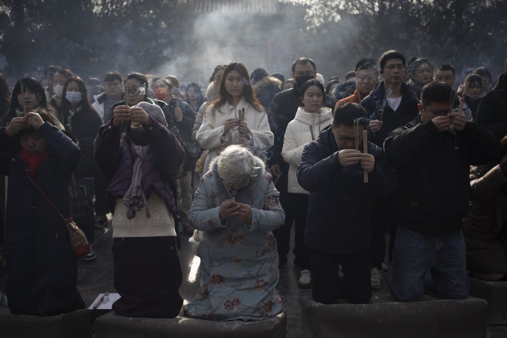 People young and old pray at Yonghe Temple in Beijing on January 1. After three decades of modernisation, many urban Chinese are spiritually adrift, restless and unsure of where to anchor their values in a fast-changing world. Photo: EPA-EFE