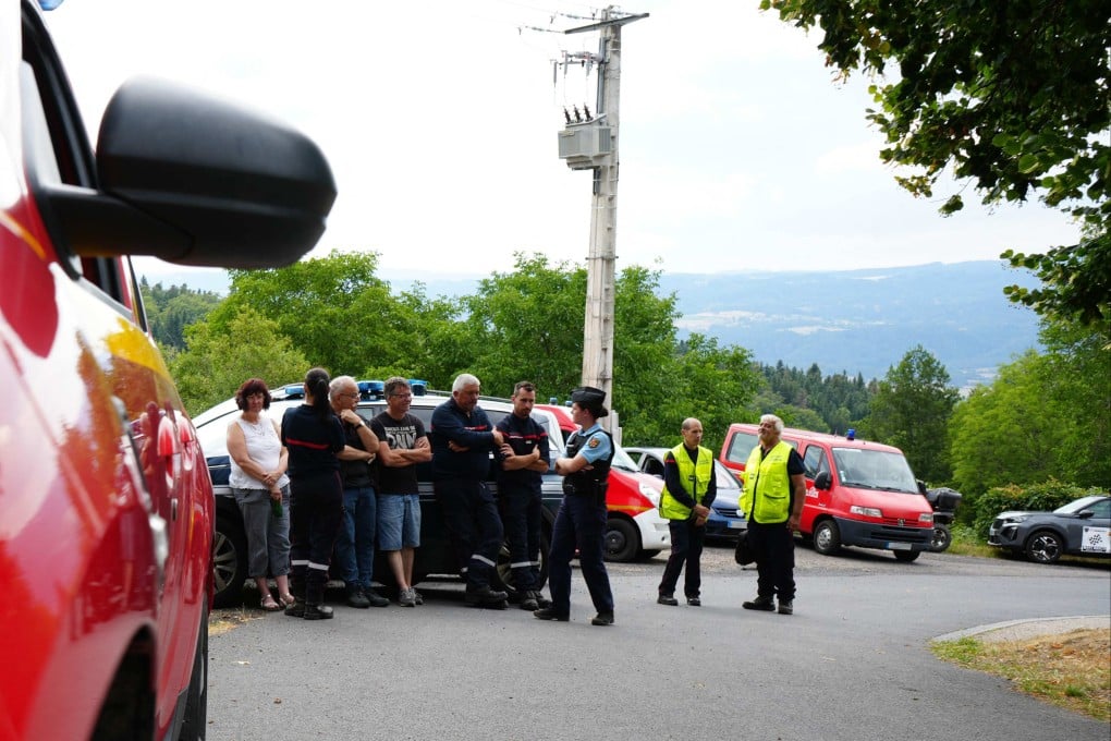 Emergency service personnel stand near the scene where spectators were killed after being hit by a car that veered off the road during an auto rally in Saint-Just, in France’s Puy-de-Dome on Saturday. Photo: AFP