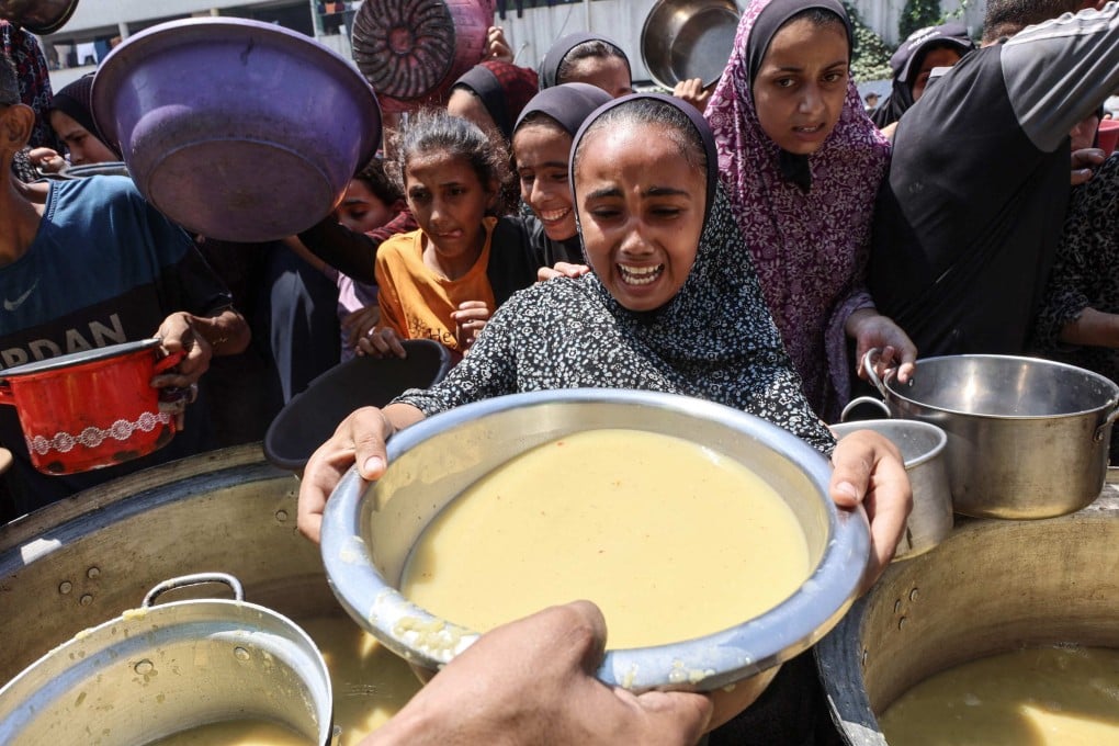 A Palestinian girl reacts as she receives lentil soup at a food distribution point in Gaza City on Friday. Photo: AFP