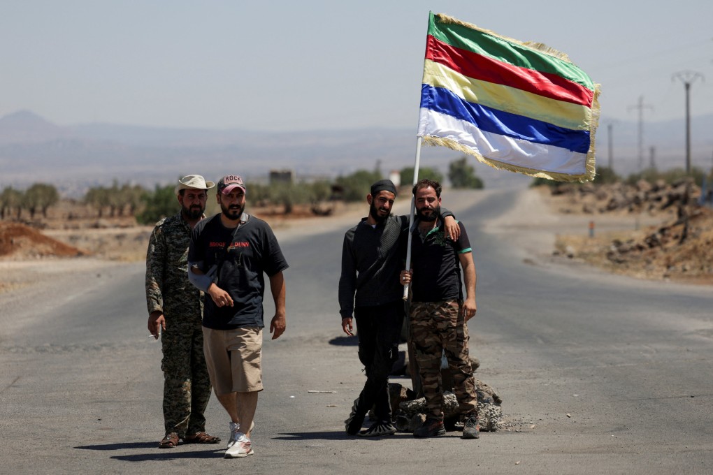 People hold a Druze flag, following deadly clashes between Druze fighters, Sunni Bedouin tribes and government forces, in Syria’s predominantly Druze city of Sweida, on Friday. Photo: Reuters