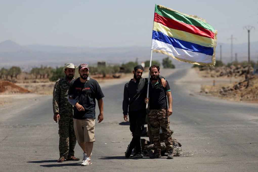People hold a Druze flag, following deadly clashes between Druze fighters, Sunni Bedouin tribes and government forces, in Syria’s predominantly Druze city of Sweida, on Friday. Photo: Reuters
