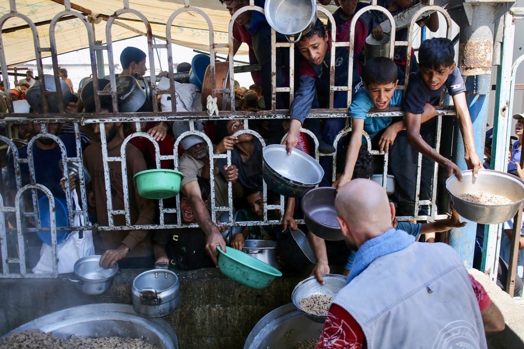 Palestinian children wait for a meal at a charity kitchen in Khan Younis in the southern Gaza Strip on Tuesday. Photo: TNS