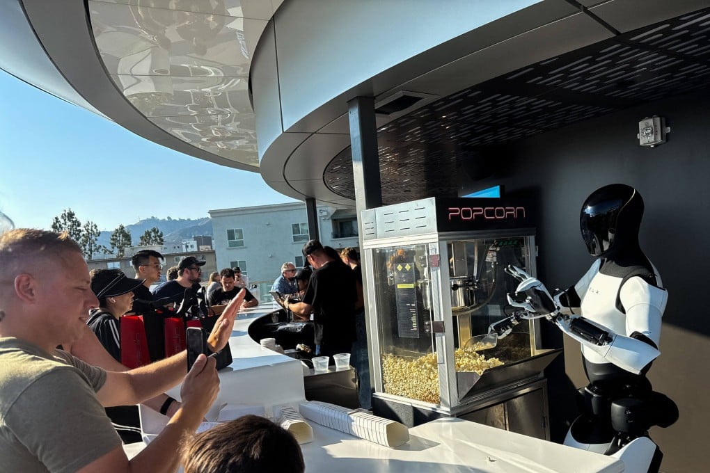 A Tesla Optimus robot scoops popcorn and gestures at attendees during the opening of the Tesla Diner and Drive-In restaurant and Supercharger in Los Angeles on July 21, 2025. Photo: AFP