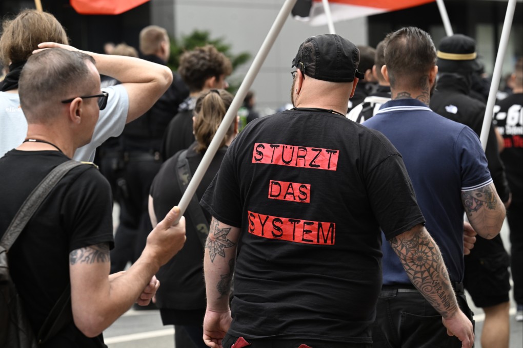 A far-right demonstrator wearing a t-shirt that reads “topple the system” protests in Germany. Photo: dpa