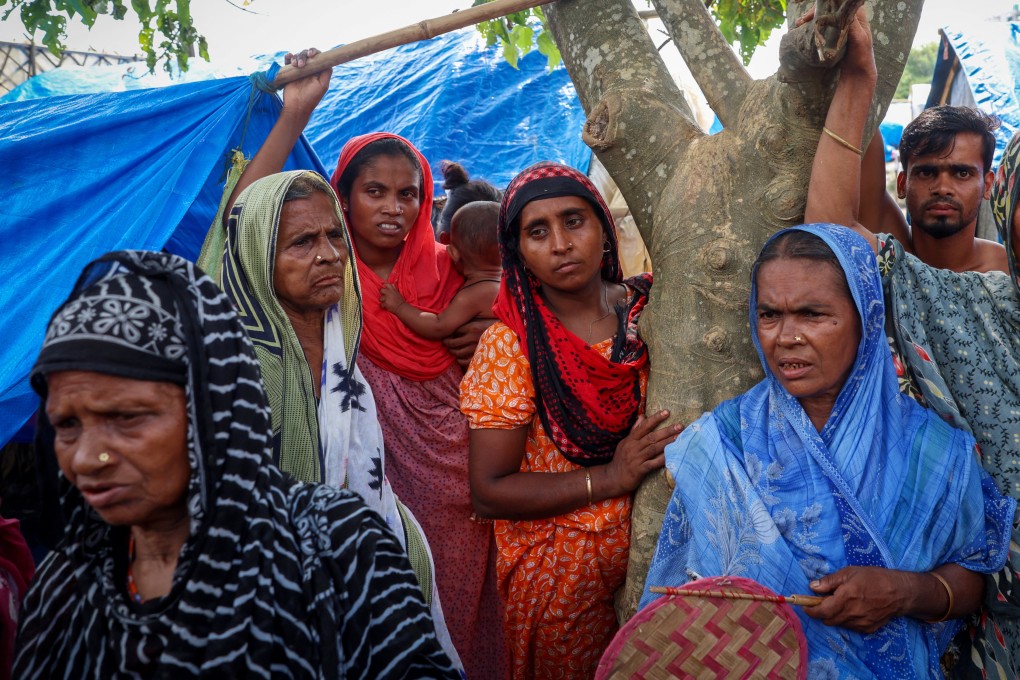 Women stand under a tree inside a makeshift shelter camp in Goalpara district in the northeastern state of Assam, India. Photo: Reuters