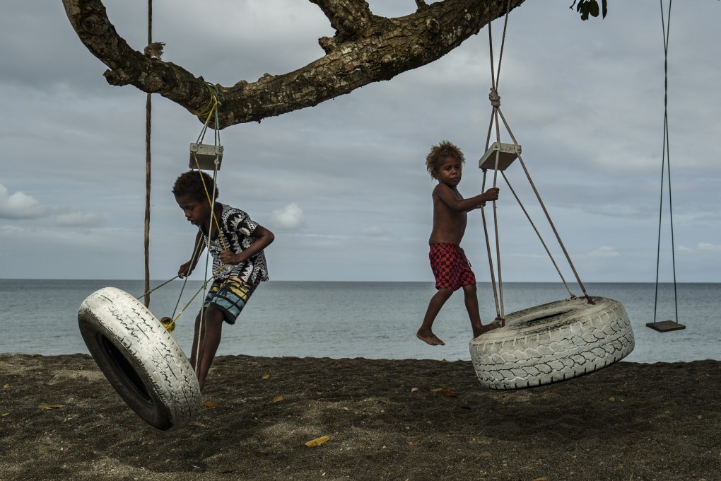 On July 19, children play with swings on an uprooted tree along a beach in Mele, Vanuatu that was once lined with vegetation lost to storms, erosion and other environmental pressures. Photo: AP