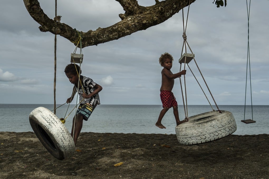 On July 19, children play with swings on an uprooted tree along a beach in Mele, Vanuatu that was once lined with vegetation lost to storms, erosion and other environmental pressures. Photo: AP