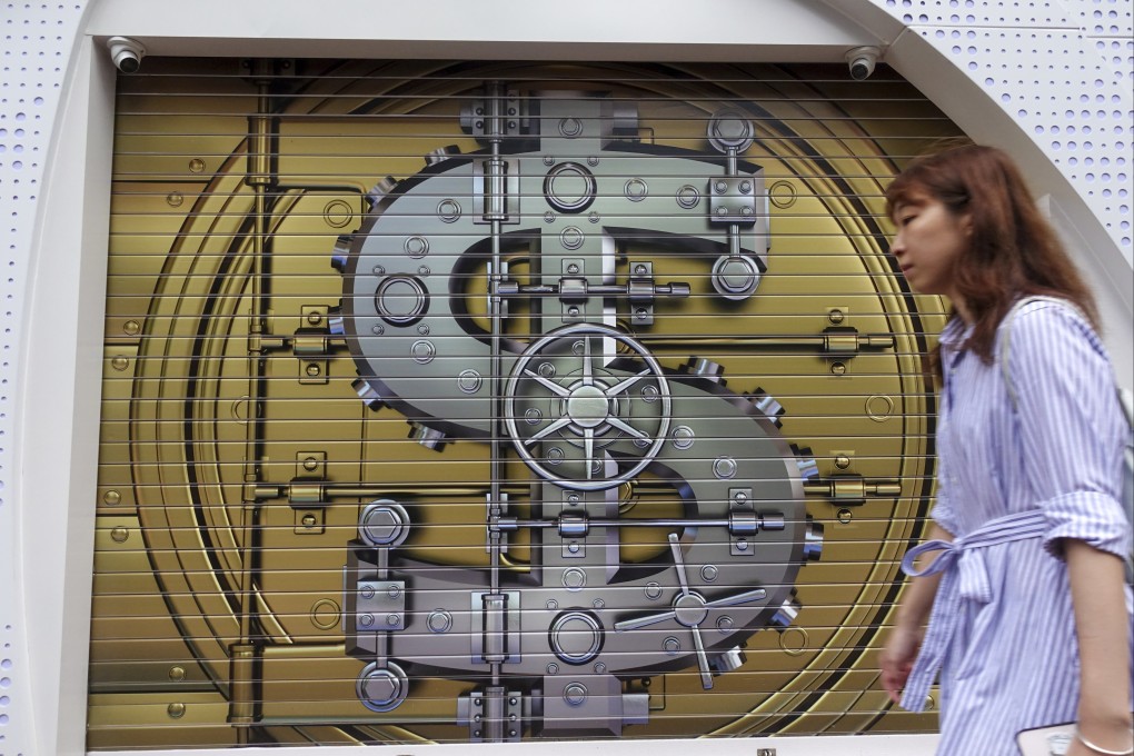 A pedestrian walks past a currency exchange shop in Causeway Bay with a bank vault painted on its gate on May 5, 2024. Photo: Jelly Tse