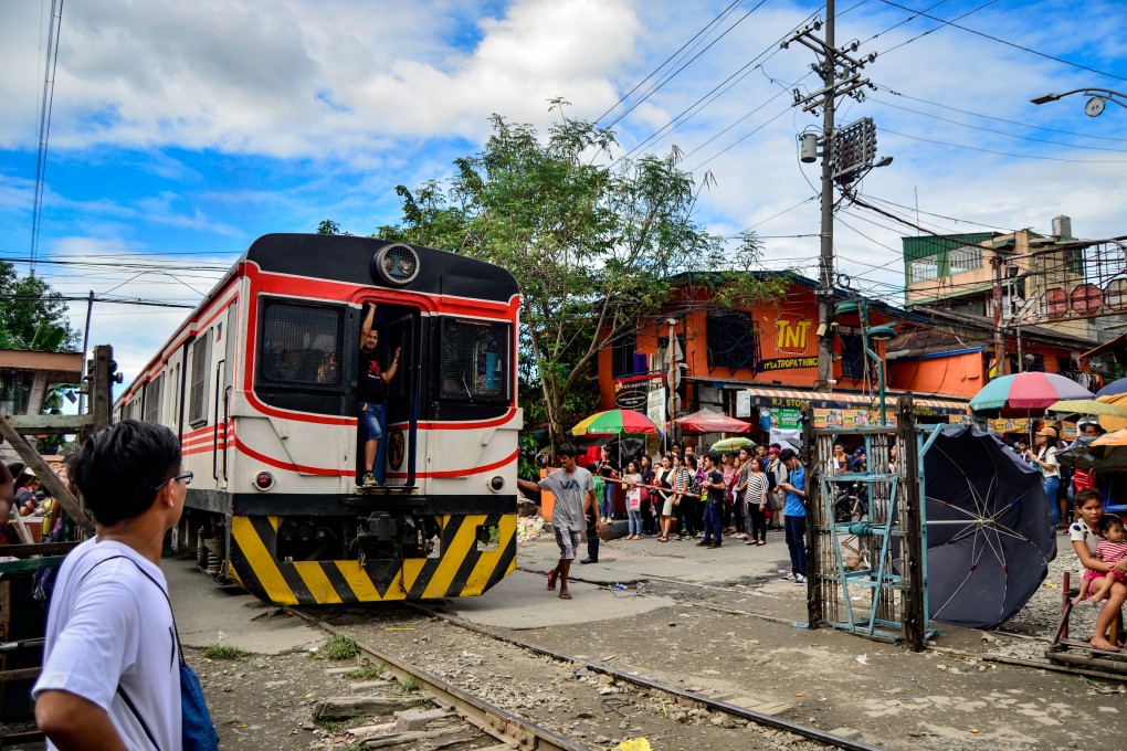 A Philippine National Railway train bisecting a busy street. The US aid package will support energy, maritime and economic growth initiatives in the country. Photo: Shutterstock