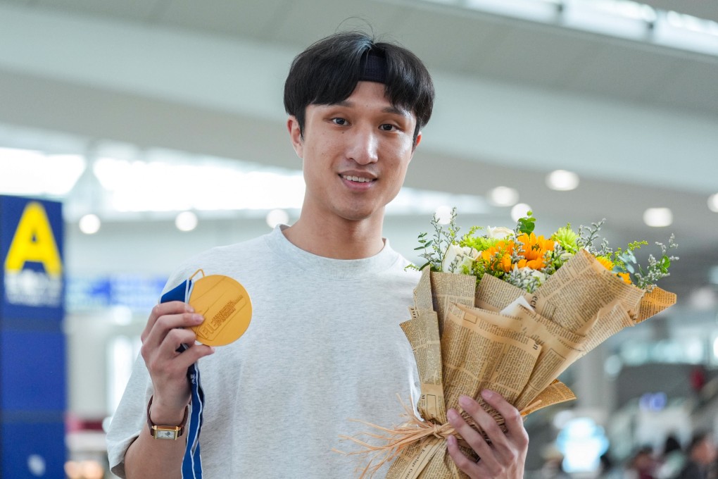 Ryan Choi displays his gold medal on arrival at Hong Kong International Airport on Monday. Photo: Eugene Lee