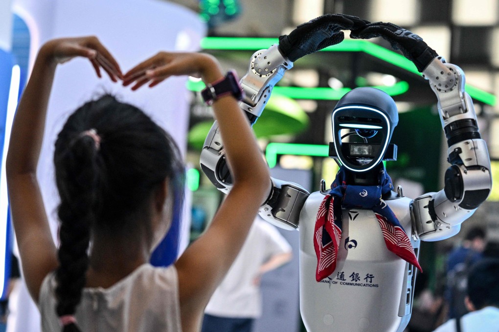 A girl plays with a humanoid robot during the World Artificial Intelligence Conference in Shanghai on July 28, 2025. Photo: AFP
