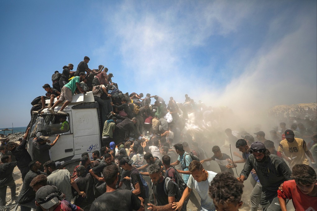 Internally displaced Palestinians try to grab bags of flour from an aid truck near a food distribution point in Zikim, northern Gaza Strip on Sunday. Photo: EPA