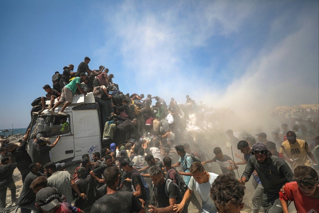 Internally displaced Palestinians try to grab bags of flour from an aid truck near a food distribution point in Zikim, northern Gaza Strip on Sunday. Photo: EPA