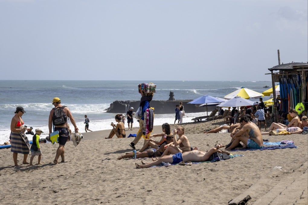 Tourists spend time at a beach in Canggu, Bali, Indonesia, earlier in July. The island’s airport handled 11.4 million passenger movements in the first half of 2025. Photo: EPA