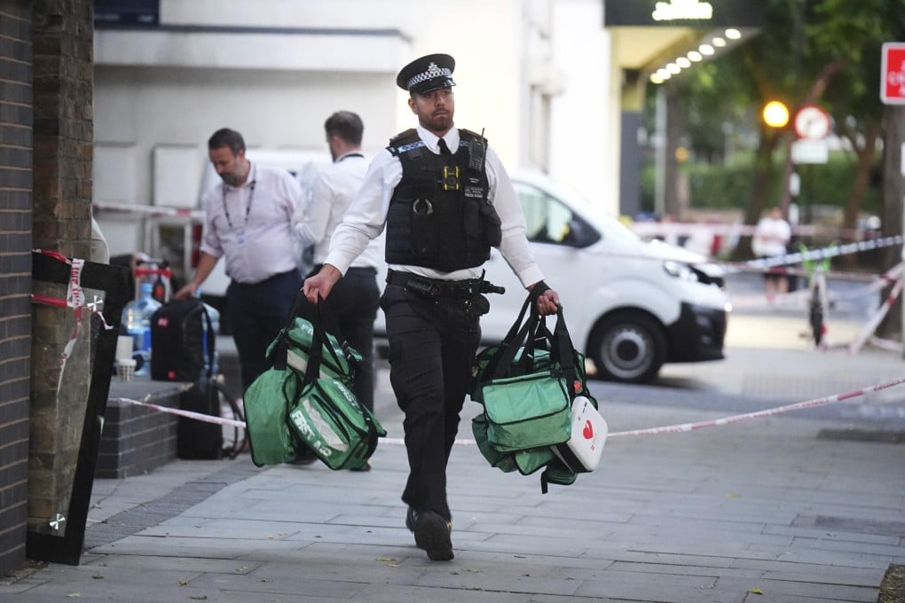 A police officer removes medical bags from the scene of a stabbing in Southwark, south London on Monday. Photo: PA via AP