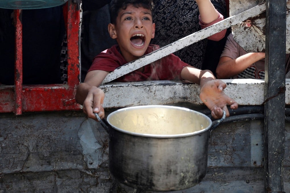 A Palestinian child reacts as he waits to receive food from a charity kitchen, amid a hunger crisis, in Gaza City on Monday. Photo: Reuters