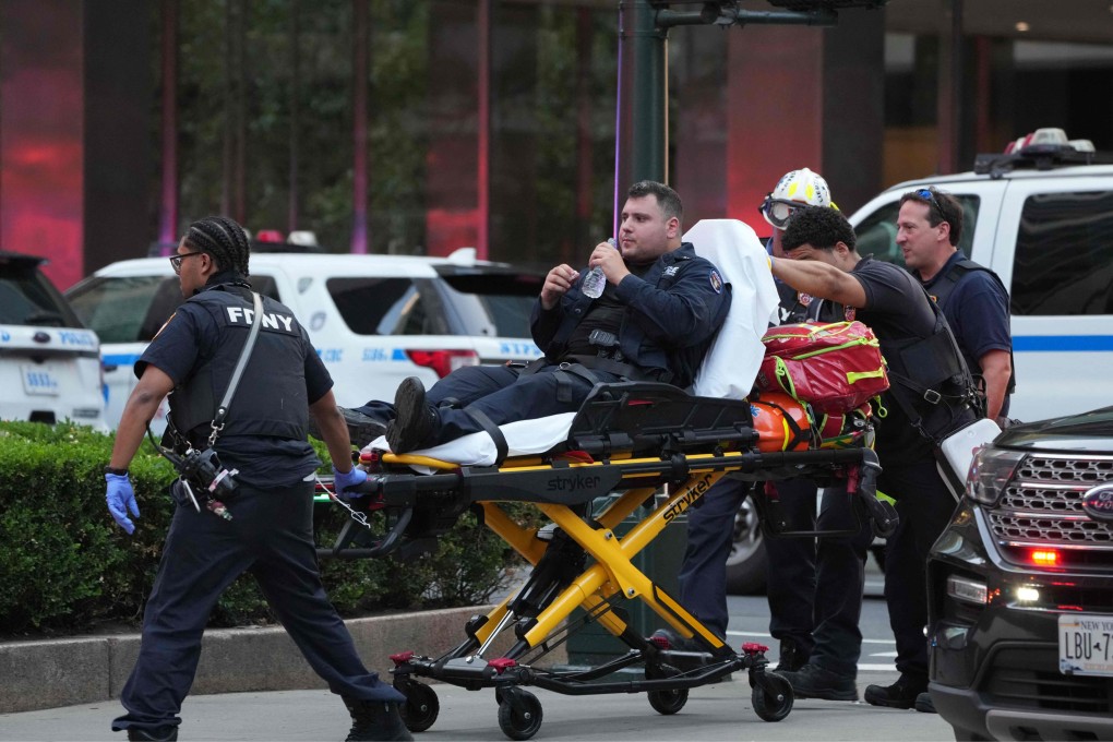 New York firefighters wheel an injured police officer on a gurney as police respond to a shooting in the Midtown Manhattan neighbourhood of New York on Monday. Photo: AFP